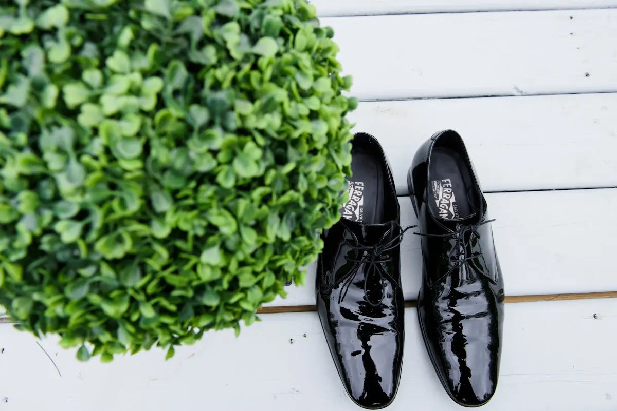 Black patent leather dress shoes with lace-up design and ’roccobarocco’ brand label.
