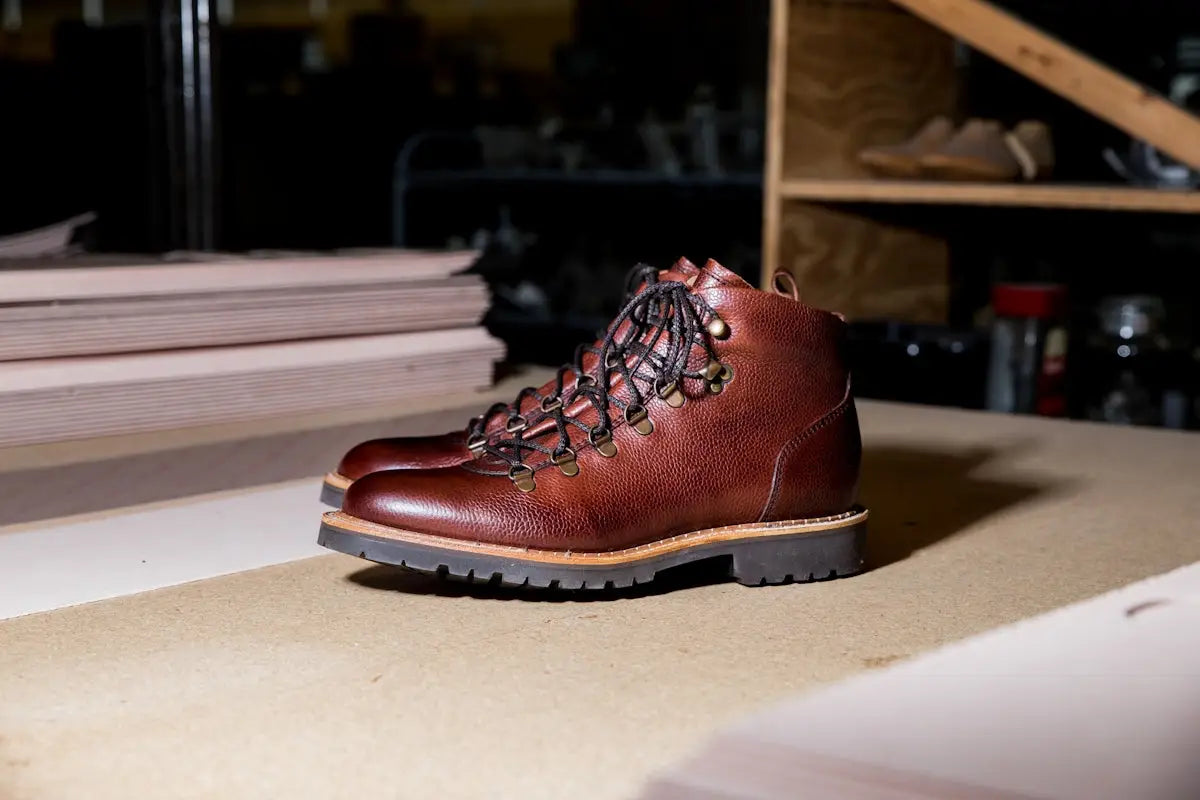 Brown leather hiking boots with laces and rubber soles.