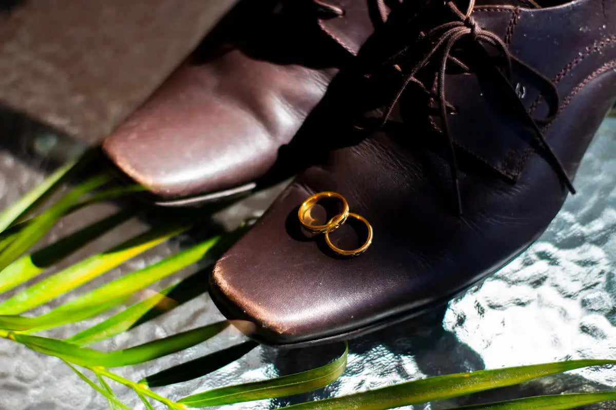 Brown leather dress shoes with gold laces and rings, classic design.