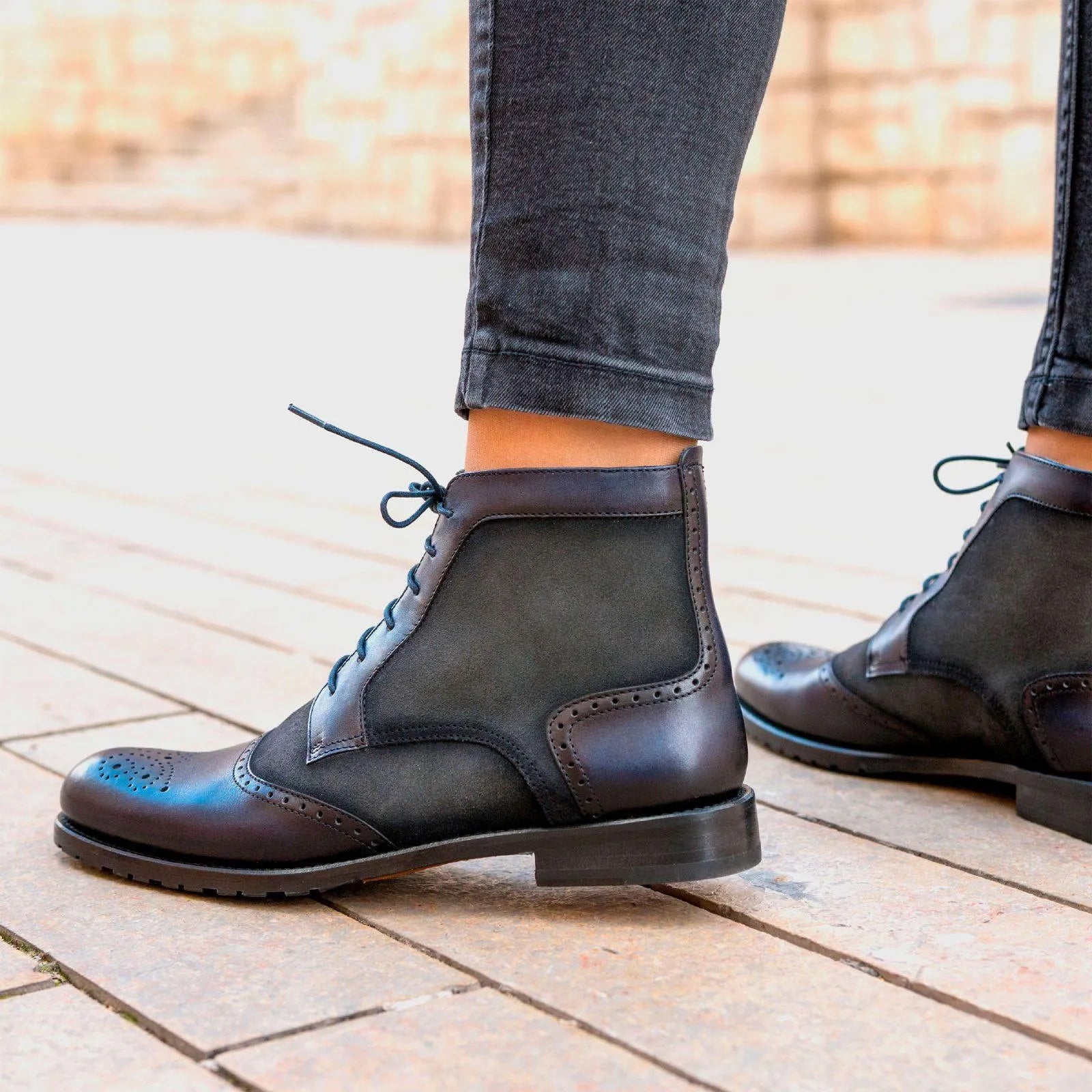 Dark brown leather brogue boots with contrasting suede panels and decorative stitching.