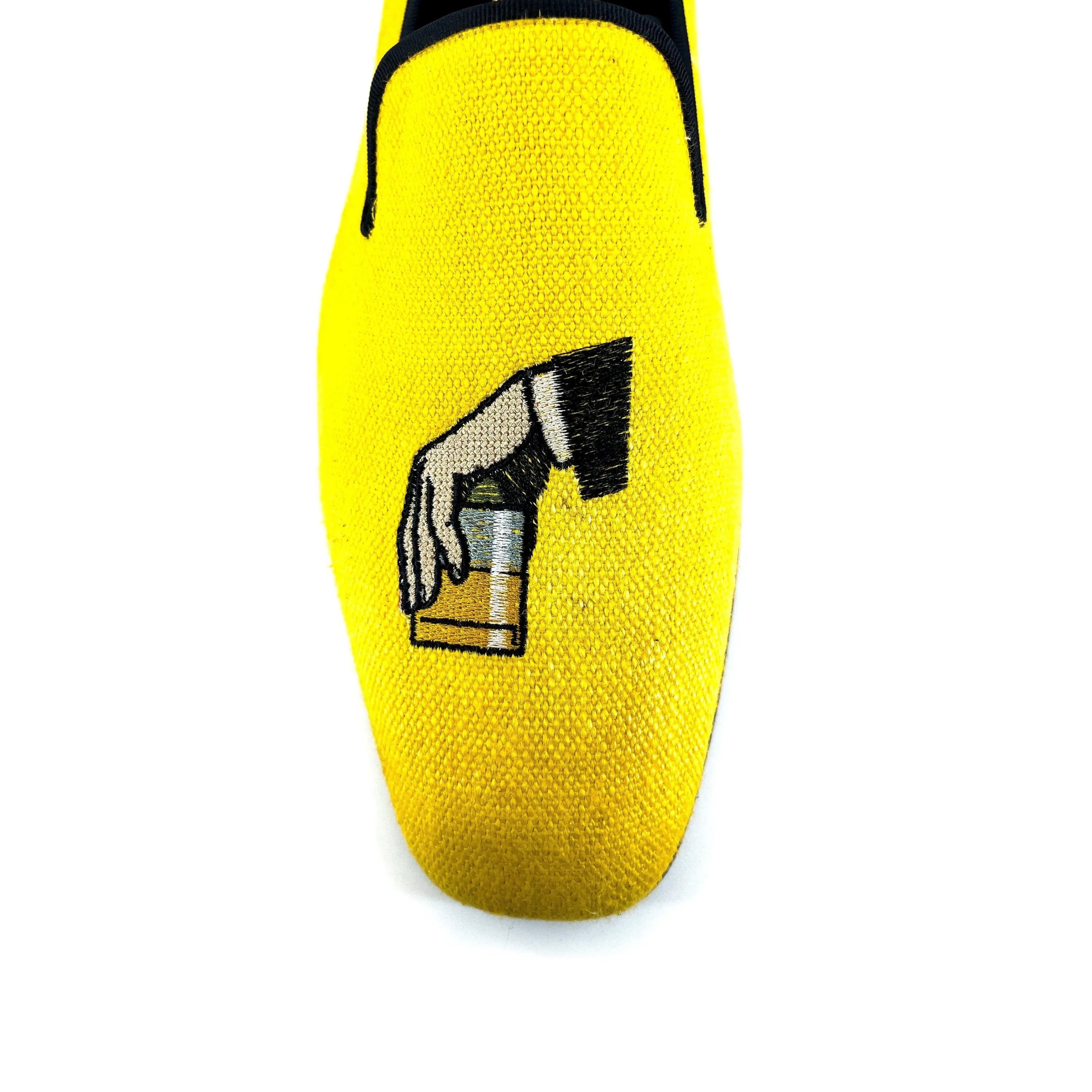 Yellow Don Drake slipon loafer with embroidered hand holding drink