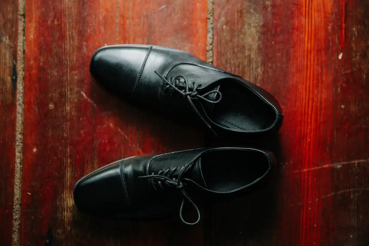 Classic black leather dress shoes with laces and polished toe cap.