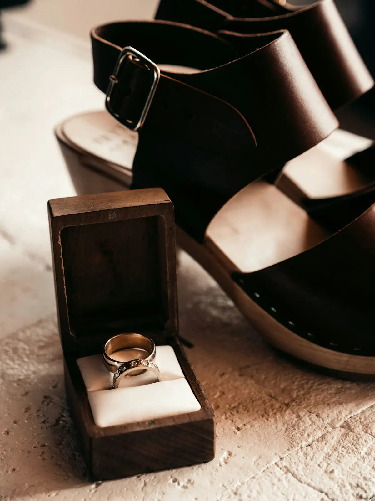 Gold wedding ring in wooden box with white lining.