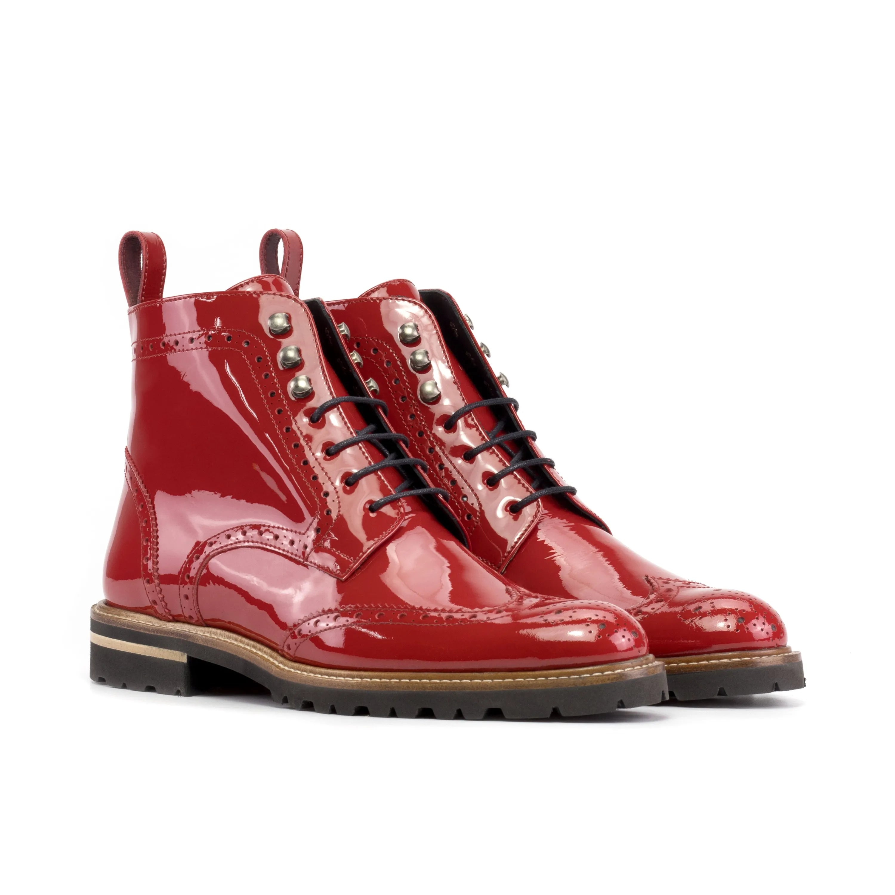 Red patent leather brogue boots with silver-toned eyelets and black laces.