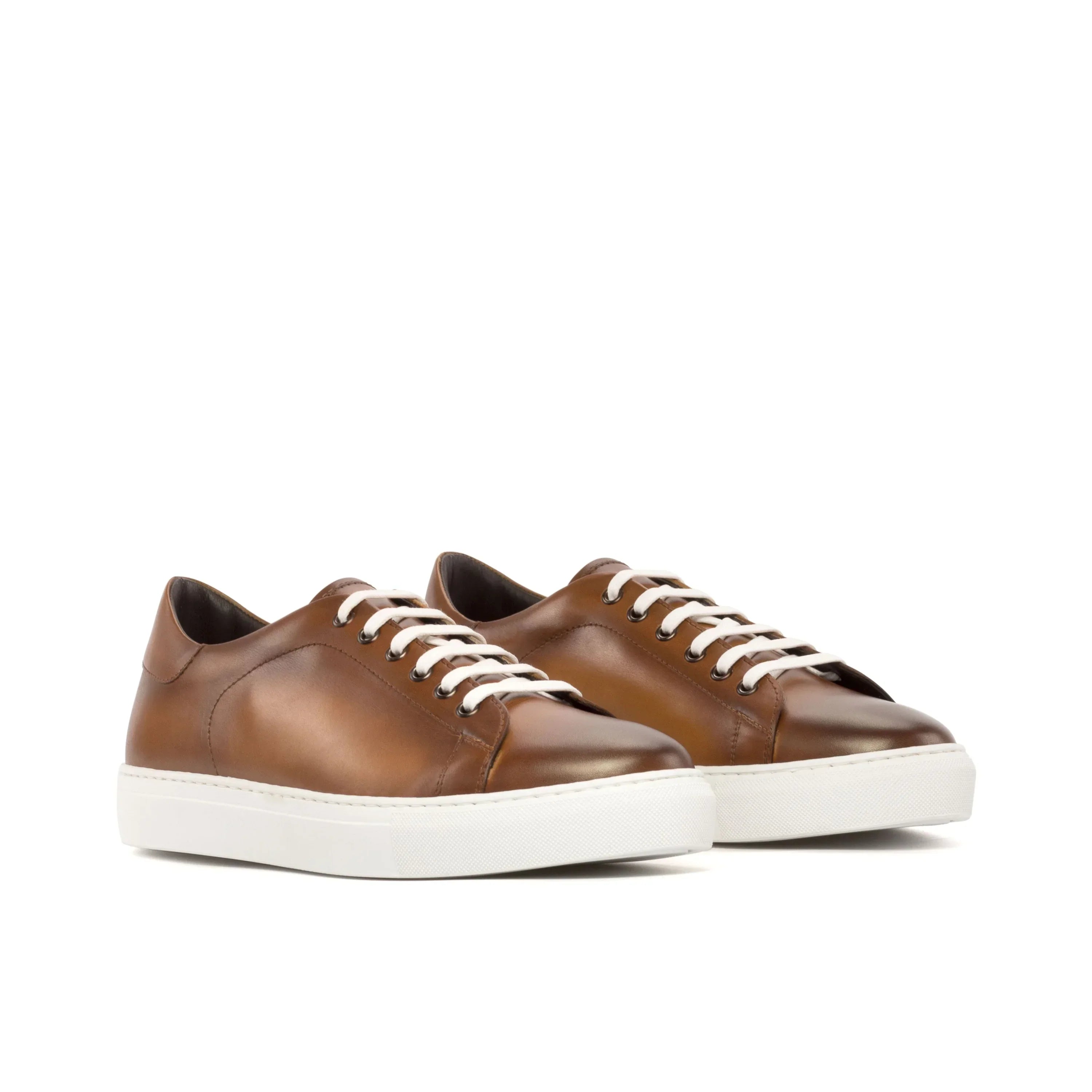 Brown leather low-top sneakers with white laces and a thick white rubber sole.