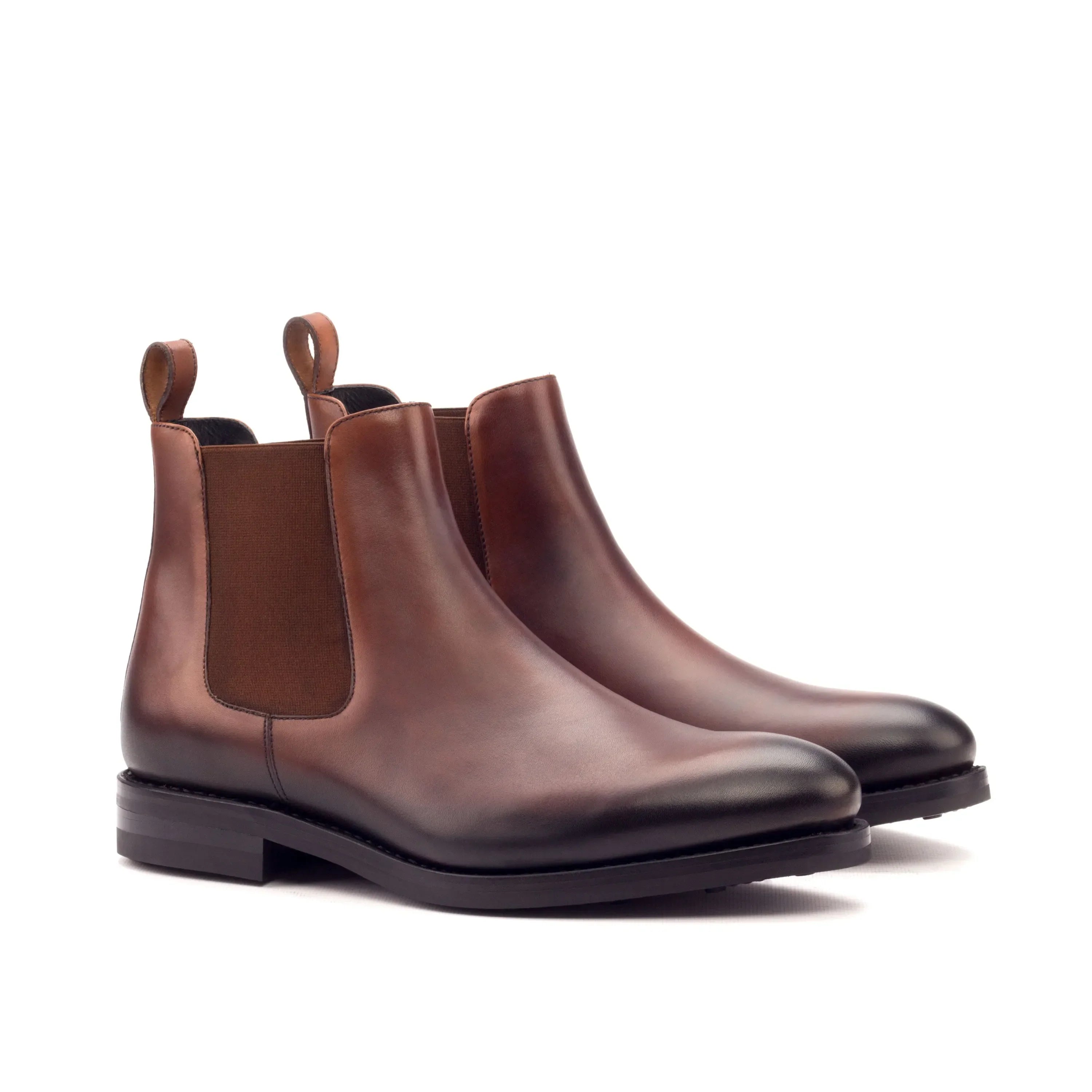 Brown leather chelsea boots with elastic side panels and pull tabs.
