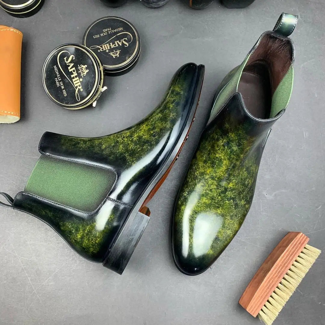 Green and black leather Chelsea boots.