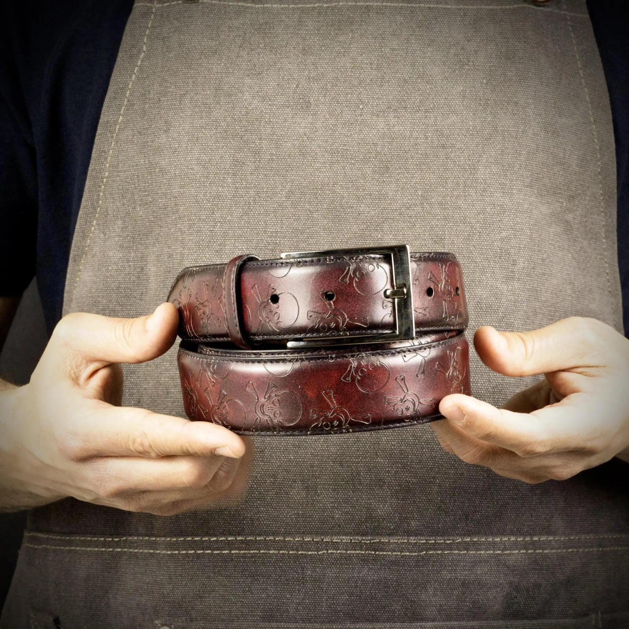 Burgundy leather belts with skull pattern.